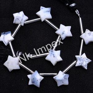 May include: A strand of white and black star-shaped opal beads with silver spacers. The beads are strung on a silver chain with a black tassel.
