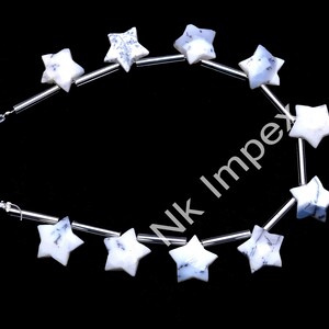 May include: A strand of white star-shaped beads with blue and grey marbling. The beads are strung on silver wire.