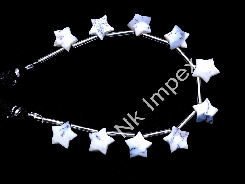 May include: A strand of white star-shaped beads with blue and grey marbling. The beads are strung on silver wire.