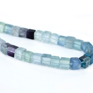 May include: A strand of square-shaped gemstone beads in shades of green, blue, and purple. The beads are arranged in a gradient pattern, starting with green and transitioning to blue and then purple.