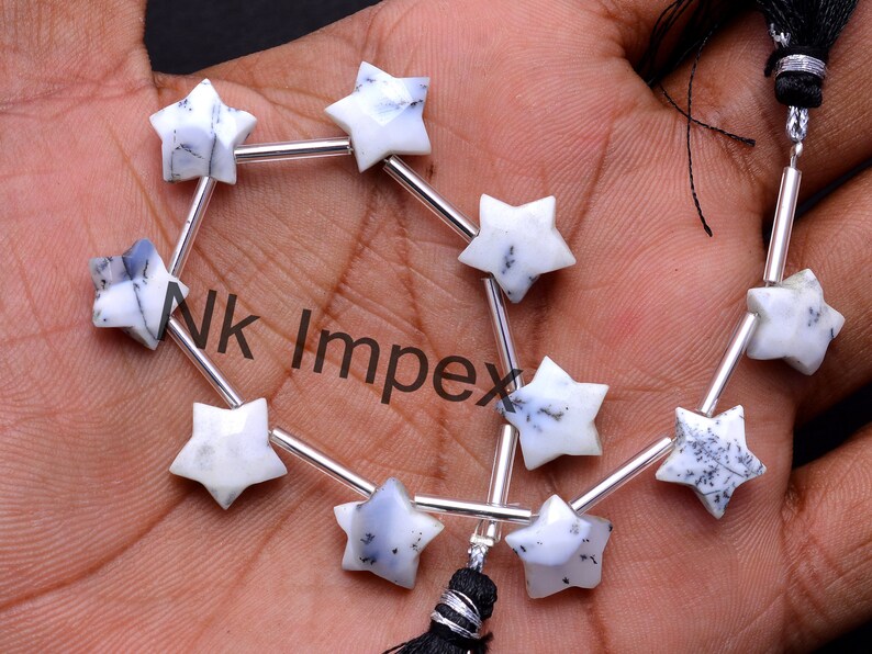 May include: A strand of white and black star-shaped gemstone beads strung on silver wire with a black tassel. The beads are approximately 10mm in size.