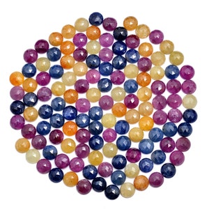 May include: A collection of faceted gemstone beads in shades of blue, purple, yellow, and orange. The beads are arranged in a circular pattern on a white background.
