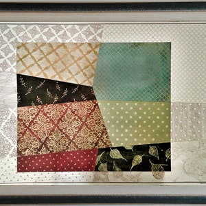 Könnte beinhalten: Ein gerahmtes abstraktes Kunstwerk mit Patchwork-Design. Das Kunstwerk zeigt verschiedene Muster und Farben, darunter Braun, Grün, Rot und Gold.