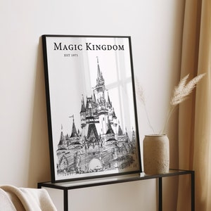 Może przedstawiać: Czarno-biały wydruk liniowy zamku Kopciuszka w Magic Kingdom w Walt Disney World. Wydruk jest oprawiony w czarną ramę i zawiera tekst "Magic Kingdom Est 1971" u góry.