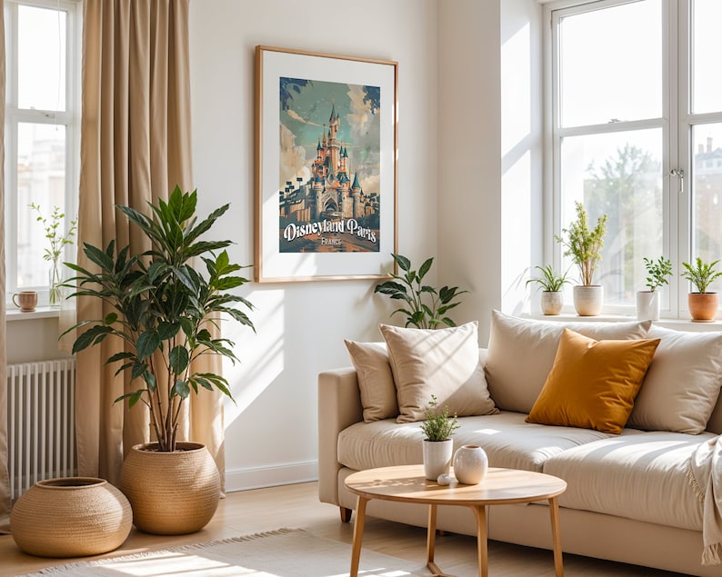 May include: A beige living room with a white couch, a coffee table, and a framed poster of Disneyland Paris. The poster features a vintage-style illustration of the iconic castle.