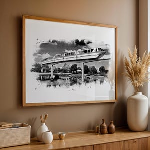Può includere: Una stampa ad acquerello in bianco e nero di un treno monorotaia che viaggia su un ponte. La stampa è incorniciata in una cornice di legno chiaro ed è appesa a un muro.