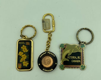 3 Vintage Canada Souvenir Keychains Includes 1995 Lucky Penny Spinner, Collectors World Dogwood Flower & Flag, 1996 Pinnacle Designs Dolphin