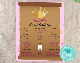 Può includere: Un biglietto di primo compleanno rosa e marrone a forma di rotolo con una corona dorata, un'immagine di un dente e il testo "Isabelle's First Birthday". Il biglietto elenca il peso, l'altezza, il libro preferito, il soprannome, il cibo preferito, cosa sa fare, i giocattoli preferiti e quanti denti ha.