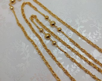 May include: A gold chain necklace with multiple strands and round beads. The necklace is made of a delicate chain with a subtle shine.