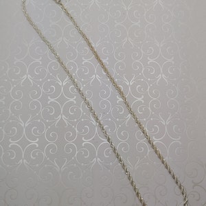 May include: A silver rope chain necklace with a lobster clasp.