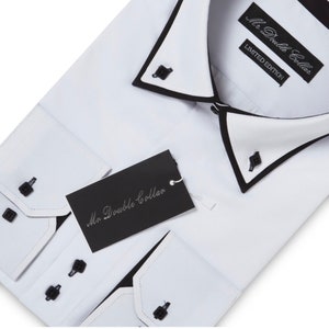 Puede incluir: Camisa blanca de vestir con un cuello doble negro y botones negros. La camisa tiene una etiqueta que dice "Mr. Double Collar" y otra etiqueta que dice "Mr. Double Collar Limited Edition".