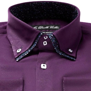 Könnte beinhalten: Nahaufnahme eines lila Hemdes mit Doppelkragen. Der Kragen und die Manschetten haben ein gemustertes Futter. Das Hemd hat weiße Knöpfe und eine Tasche. Der Text "The Double Collar" und "Limited Edition" sind sichtbar.