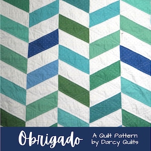 Może przedstawiać: Wzór patchworku o nazwie "Obrigado" autorstwa Darcy Quilts. Patchwork wykonany jest z niebieskiego, zielonego i białego materiału i ma wzór w jodełkę.