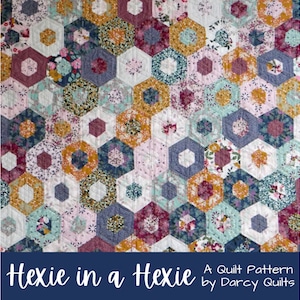 Puede incluir: Un patrón de colcha llamado "Hexie in a Hexie" de Darcy Quilts. La colcha está hecha de hexágonos coloridos en tonos de rosa, azul, verde, amarillo y rojo. Los hexágonos están hechos de tela floral.