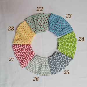 May include: Ten colorful polka dot skirts in various colors, including yellow, red, green, blue, and gray. The skirts are arranged in a circle with the numbers 22, 23, 24, 25, 26, 27, and 28 visible.