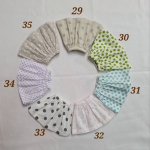 May include: Seven different polka dot skirts in various colors, including white, gray, light blue, green, purple, and pink. Each skirt has a number from 29 to 35 printed on it.