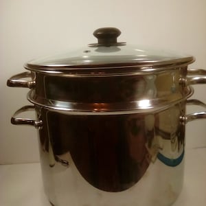 May include: Stainless steel steamer pot with a glass lid and two tiers. The pot has two handles on each side.