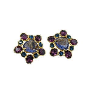 May include: A pair of gold tone clip-on earrings with a cluster of purple, blue, and clear rhinestones.