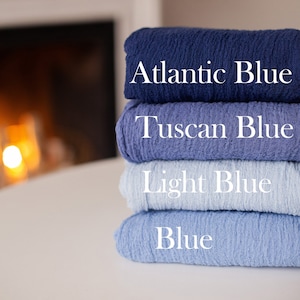 Op de afbeelding: Vier stofstalen die op elkaar gestapeld zijn. De stalen zijn in verschillende tinten blauw, van donkerblauw tot lichtblauw. De stalen zijn gelabeld met "Atlantic Blue", "Tuscan Blue", "Light Blue" en "Blue".
