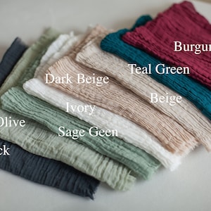 以下が含まれることがあります： 黒、オリーブ、セージグリーン、アイボリー、ダークベージュ、ベージュ、ティールグリーン、バーガンディーなど、さまざまな色のファブリックスワッチが10枚重ねられています。スワッチは、最も暗いものから最も明るいものへと配置されています。