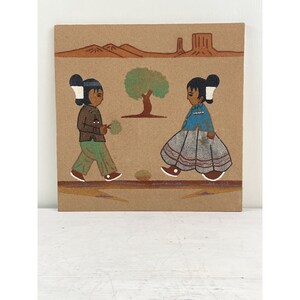 May include: A sand painting showing two figures in traditional Native American dress walking towards each other. The figures are set against a tan background with a tree, mountains, and a mesa. The figures are wearing brown, blue, and green clothing.