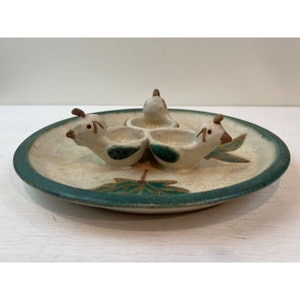May include: A ceramic serving dish with three bird-shaped compartments. The dish is off-white with a green rim and leaf design. The birds are white with brown accents and green details, creating a charming, handcrafted aesthetic.