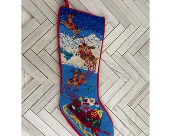 Calcetín navideño vintage bordado a mano: Papá Noel en trineo con renos.