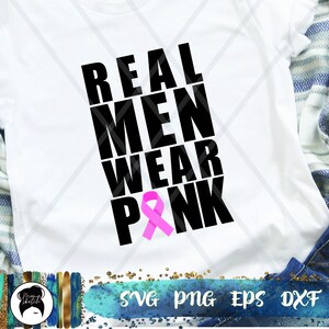 May include: White t-shirt with black text that reads "REAL MEN WEAR PINK" and a pink ribbon.