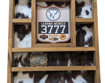 Expositor de hebillas de cinturón de piel de vaca hecho a mano a medida: tiene capacidad para 8 hebillas, 4 cuchillos trofeo y números de rodeo.