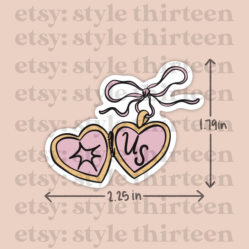 May include: A pink and gold heart-shaped locket with a ribbon and the word "Us" inside. The locket is 2.25 inches wide and 1.79 inches tall.
