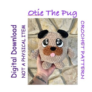 May include: Crochet pattern for a plush pug toy named "Otie The Pug". The toy is brown and tan with black ears and large eyes. The toy is being held in a hand with a tattoo that says "Believe".
