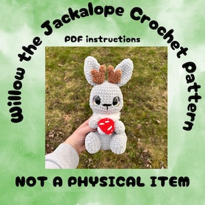 May include: Crochet pattern for a gray Jackalope with brown antlers holding a red heart. The pattern is called "Willow the Jackalope Crochet Pattern" and includes PDF instructions. The text "Not a physical item" is also included in the image.