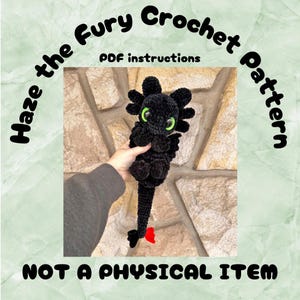 Könnte beinhalten: Häkelmuster für einen schwarzen und grünen Drachen mit dem Text "Haze the Fury Crochet Pattern" und "PDF instructions" auf einem Steinmauerhintergrund. Der Text "NOT A PHYSICAL ITEM" befindet sich am unteren Rand des Bildes.