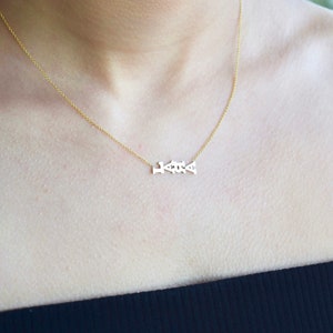 Puede incluir: Un collar de cadena de oro con un delicado colgante que deletrea la palabra "Love".