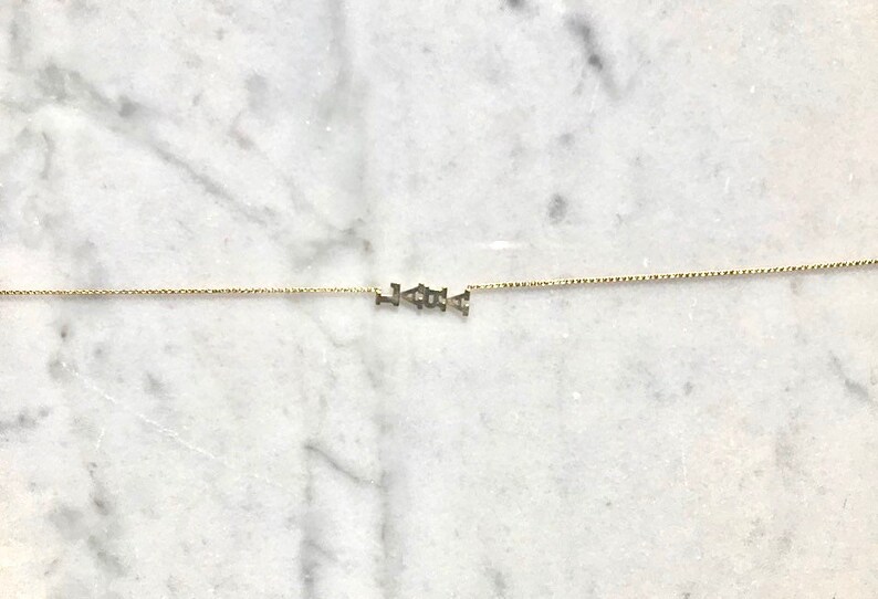 Puede incluir: Un collar de cadena de oro con la palabra "LOVE" escrita en letras peque&ntilde;as.