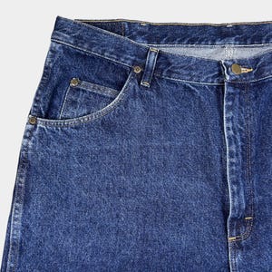 Pu&ograve; includere: Un paio di jeans blu denim con un classico design a cinque tasche. I jeans hanno un lavaggio chiaro e un aspetto sbiadito.
