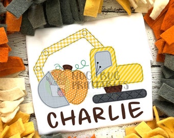 Puede incluir: Una aplicación bordada de un vehículo de construcción amarillo y negro excavando una calabaza. El nombre "CHARLIE" está bordado debajo de la aplicación.