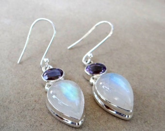Peut inclure: Une paire de boucles d'oreilles pendantes en argent avec une pierre de lune en forme de larme et une petite pierre d'améthyste ronde.