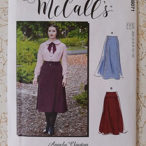 Könnte beinhalten: Ein McCall's Schnittmuster mit einer Frau in einer rosa Bluse und einem bordeauxfarbenen Rock. Das Muster enthält Illustrationen von zwei Rockdesigns. Der Text enthält "McCall's", "M8071", "SIZE AX5 (4-6-8-10-12)" und "Angela Clayton".