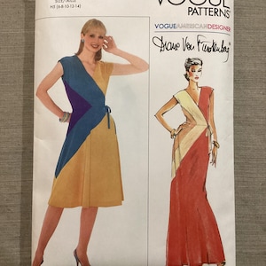 Könnte beinhalten: Vogue Patterns Schnittmuster mit einem Wickelkleid-Design. Das Muster enthält eine farbige Illustration des Kleides in Gelb, Blau und Lila sowie eine weitere in Rot und Creme. Das Muster ist mit V2100 gekennzeichnet und enthält die Unterschrift des Designers.