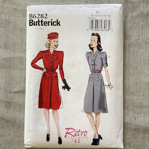 Op de afbeelding: Een vintage Butterick naaipatroon, B6282, met illustraties van twee retro jurken. Het patroon bevat maten 8-16. De cover heeft de tekst "Retro '41". De jurk ontwerpen zijn in rood en grijs.