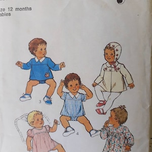 May include: Vintage sewing pattern featuring illustrations of baby clothing designs. The pattern includes drawings of a blue romper with a teddy bear, a pink dress, a striped romper, a floral top, and a white coat with a bonnet. The word "Style" is at the top.
