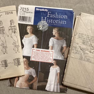 Puede incluir: Tres patrones de costura vintage para ropa histórica. El patrón central, "The Fashion Historian", presenta imágenes de una mujer con un vestido blanco. Los otros patrones muestran ilustraciones de vestidos y corsés. Los patrones están etiquetados con tallas y una advertencia de incendio.