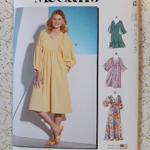 Op de afbeelding: McCall's naaipatroon M8312 met een vrouw in een gele gingham jurk. Het patroon bevat illustraties van verschillende jurkstijlen, met maat ZZ (LRG-XLG-XXL). De tekst "Designed and printed in USA" is ook zichtbaar.