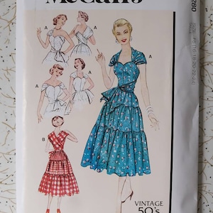 Puede incluir: Patrón de costura vintage McCall's M8280 de los años 50 para las tallas F5 (16-18-20-22-24). El patrón presenta un vestido con un escote de corazón y un lazo en la cintura. El vestido se muestra en tres estilos diferentes, incluyendo un estampado floral azul, un estampado de cuadros rojos y blancos y un blanco sólido.