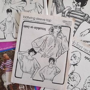 May include: Four vintage sewing patterns for knit tops with batwing sleeves. The patterns are printed on white paper with black ink and feature illustrations of women wearing the tops. The patterns are titled "Knit-N-Stretch" and include instructions for different neckline variations.