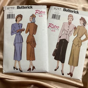 Peut inclure: Deux enveloppes de patrons de couture Butterick vintage. L'une présente une femme en tailleur lavande, l'autre en veste rose et jupe noire. Les deux enveloppes portent le texte "Retro '48".