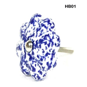 May include: Blue and white ceramic cabinet knob with a splatter pattern. The knob has a silver metal screw.