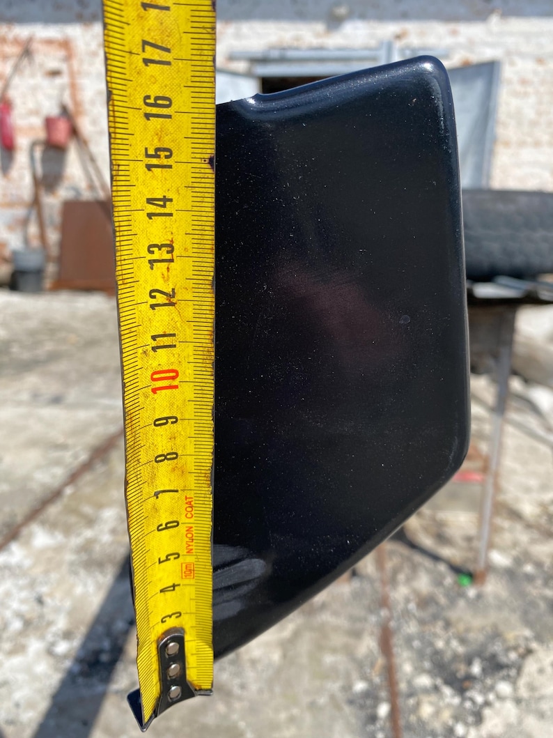 K&ouml;nnte beinhalten: Ein schwarzes, gebogenes Objekt wird mit einem gelben Ma&szlig;band gemessen. Das Ma&szlig;band zeigt eine L&auml;nge von etwa 43 cm an. Das Objekt hat eine gl&auml;nzende Oberfl&auml;che und scheint aus einem harten Material zu bestehen.