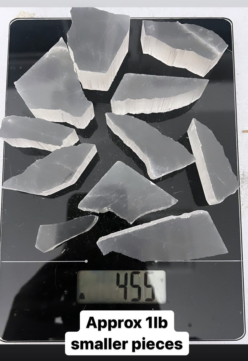 May include: A digital scale displaying 455 grams with a collection of 11 ounces of clear, broken selenite crystals. Approx 1lb smaller pieces.